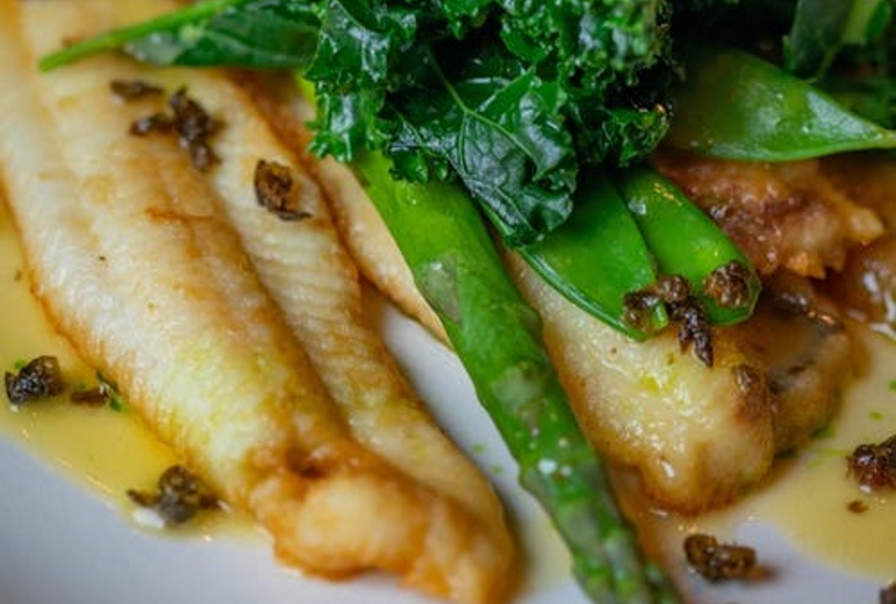 Baked bluegill fillet on a plate with asparagus.